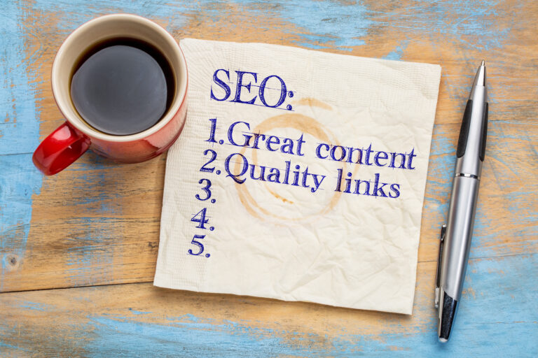 SEO Tools (search engine optimization) tips (great content and quality links) on napkin with a cup of coffee
